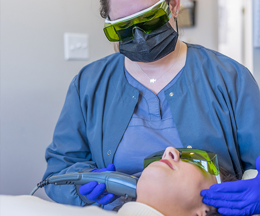 Hand holding a dental soft tissue laser