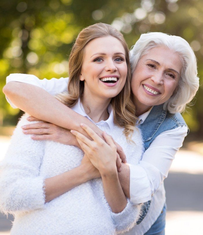 Mother and daughter hugging outdoors