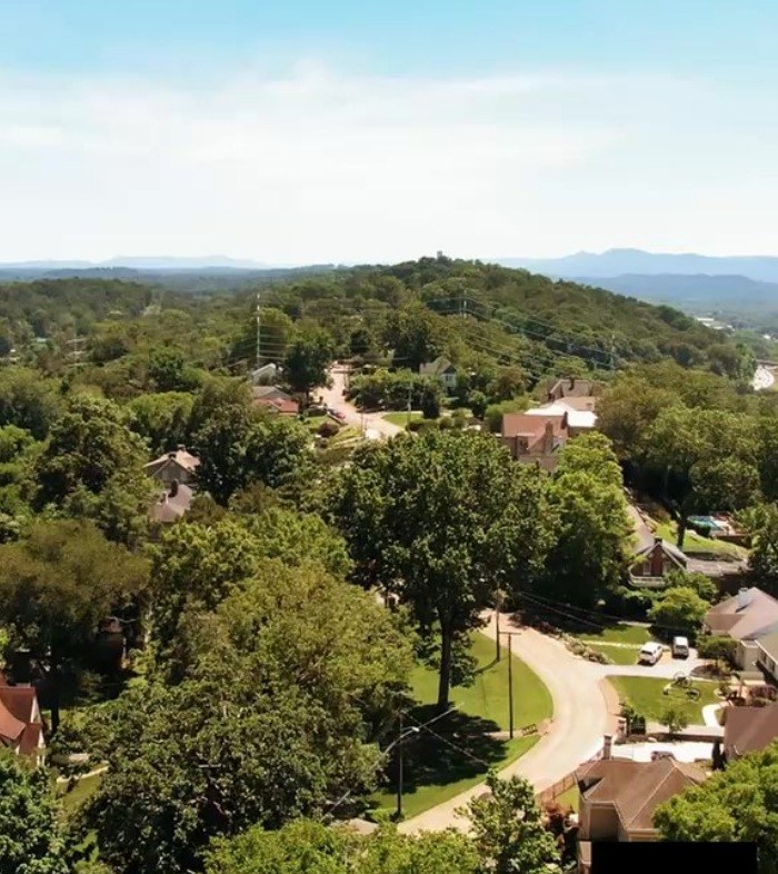 Aerial view of tree covered suburban neighborhood in Centennial with mountains in background