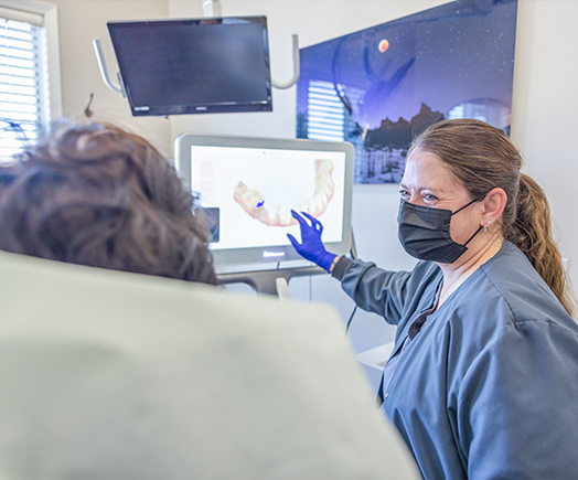 Close up of person placing Invisalign tray over their teeth