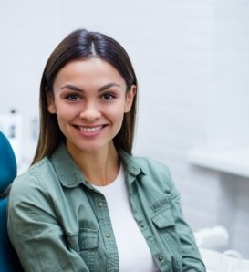 WOman in green shirt smiling in dental chair