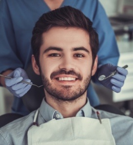 Man with short beard smiling in dental chair