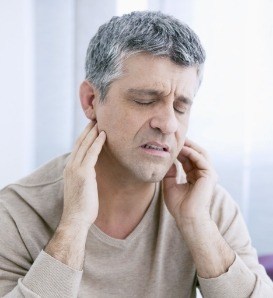 Older man holding the sides of his jaws in pain
