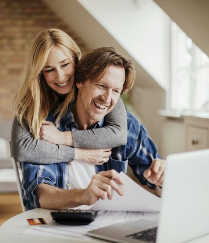 Man and woman looking at laptop reading dentist reviews in Centennial