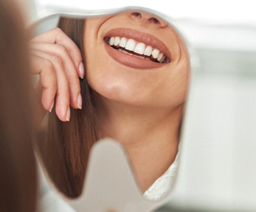 Dental patient’s beautiful teeth displayed in mirror