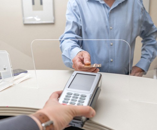 Patient using card to pay for dental treatment