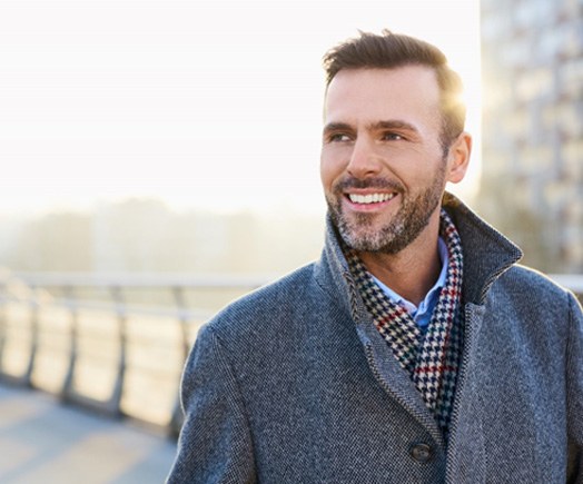 man smiling outside in the city